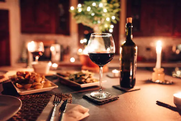 Candlelit restaurant table set with wine, warm ambient lighting